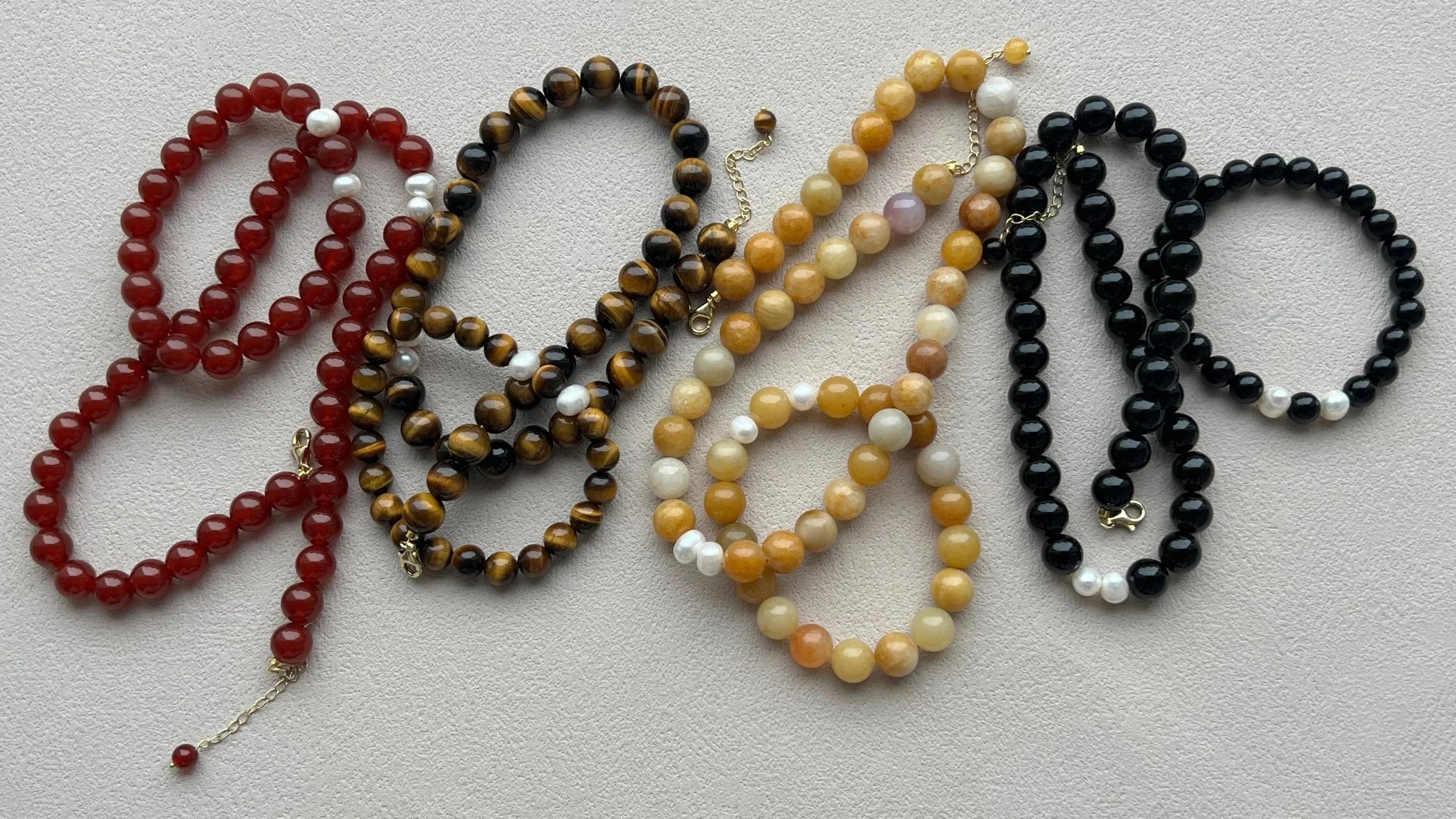 Yellow Aventurine, Tiger’s Eye, Obsidian, and Red Agate bracelet and necklace sets, showcasing natural gemstones in a stylish and harmonious design, ideal for promoting confidence, strength, and positive energy.