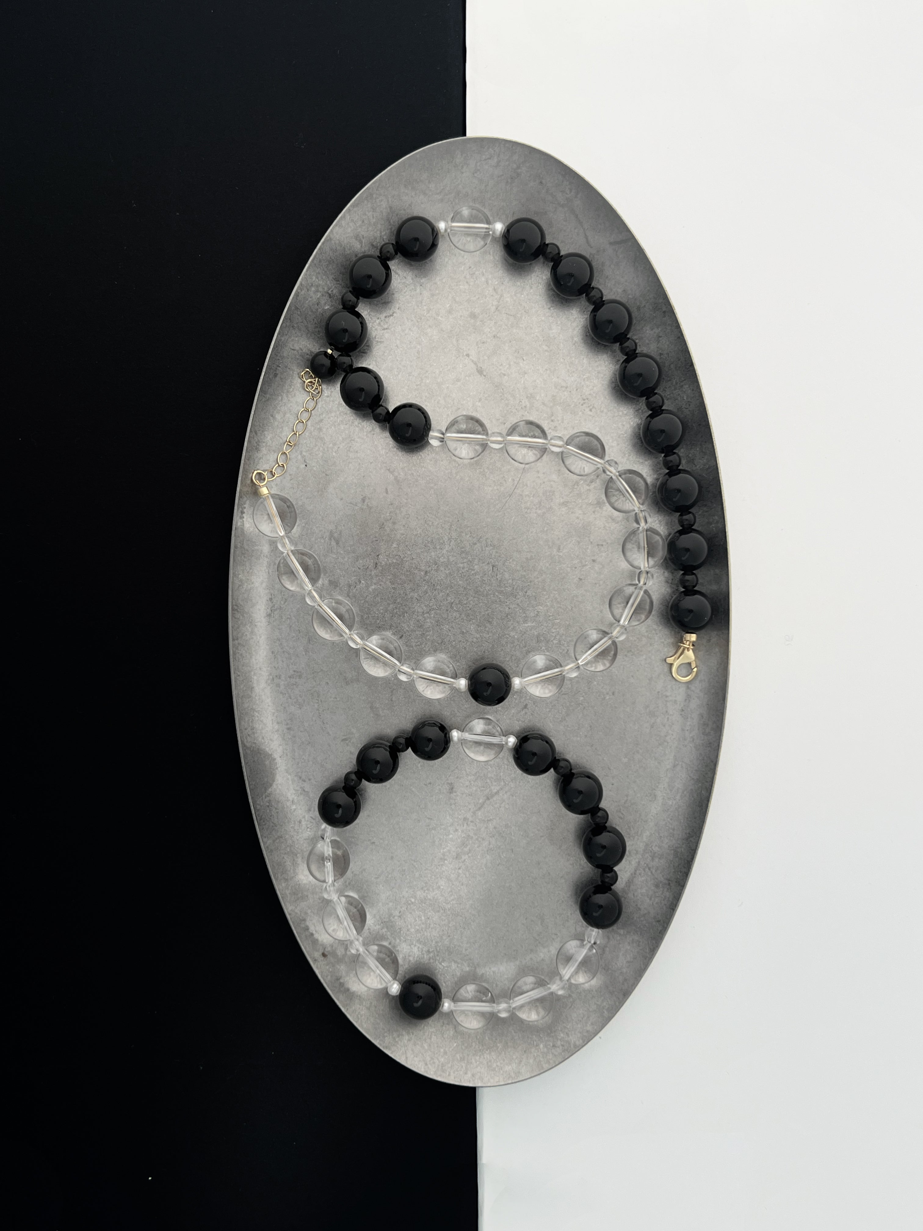 Amaré Yinyang collection hero image featuring balanced Black Obsidian and Clear Quartz crystal jewelry, embodying the harmony of light and shadow.