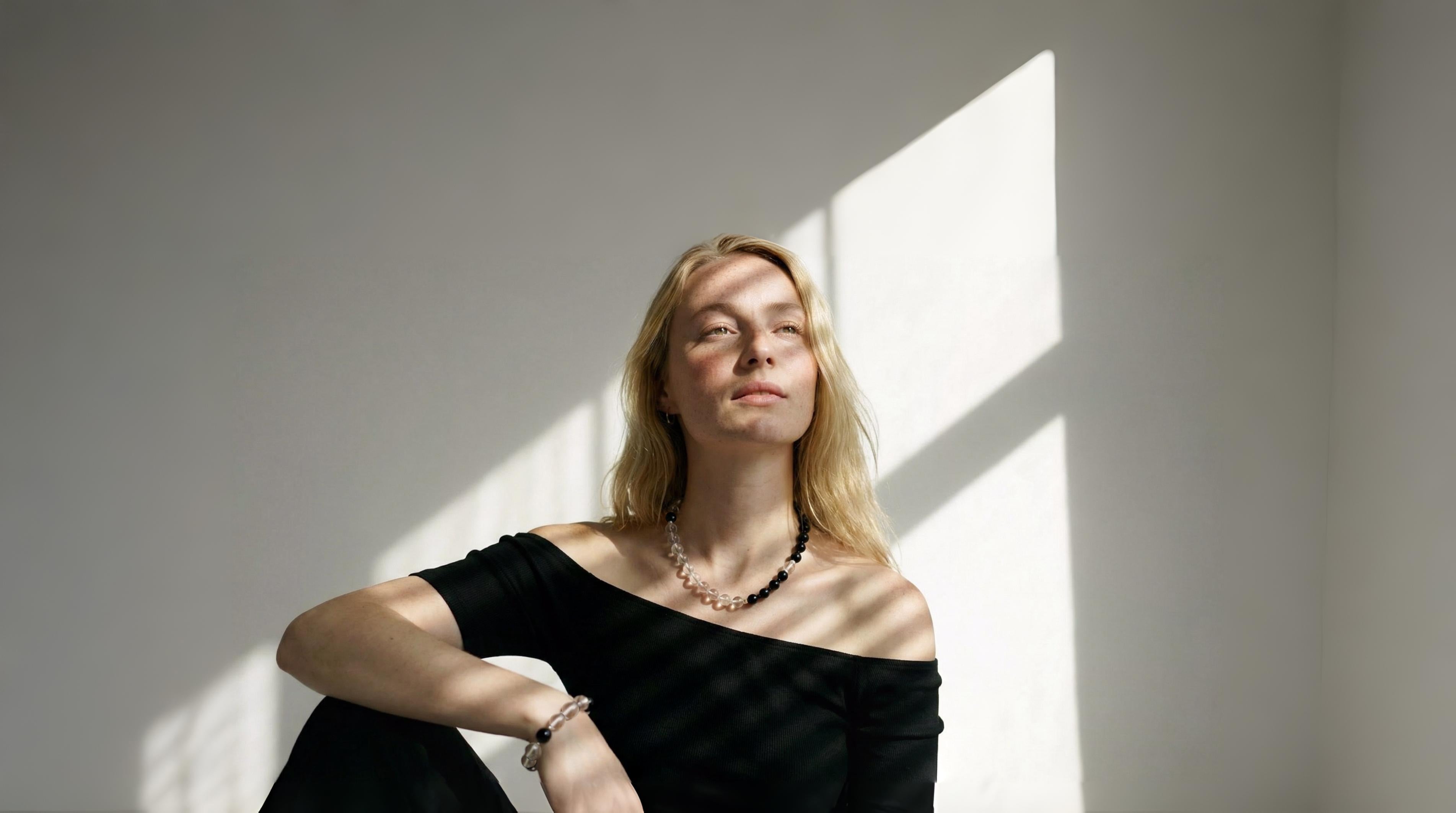 A model wearing the Amaré Yin Yang necklace and bracelet in a serene, minimalist setting, representing the Void & Form collection’s balance of Eastern heritage and Nordic design.