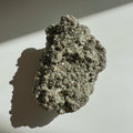 Hematite Raw Stone on a white surface with a gray background