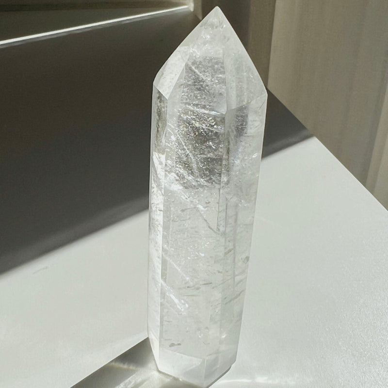 Clear crystal on a reflective surface with a neutral background