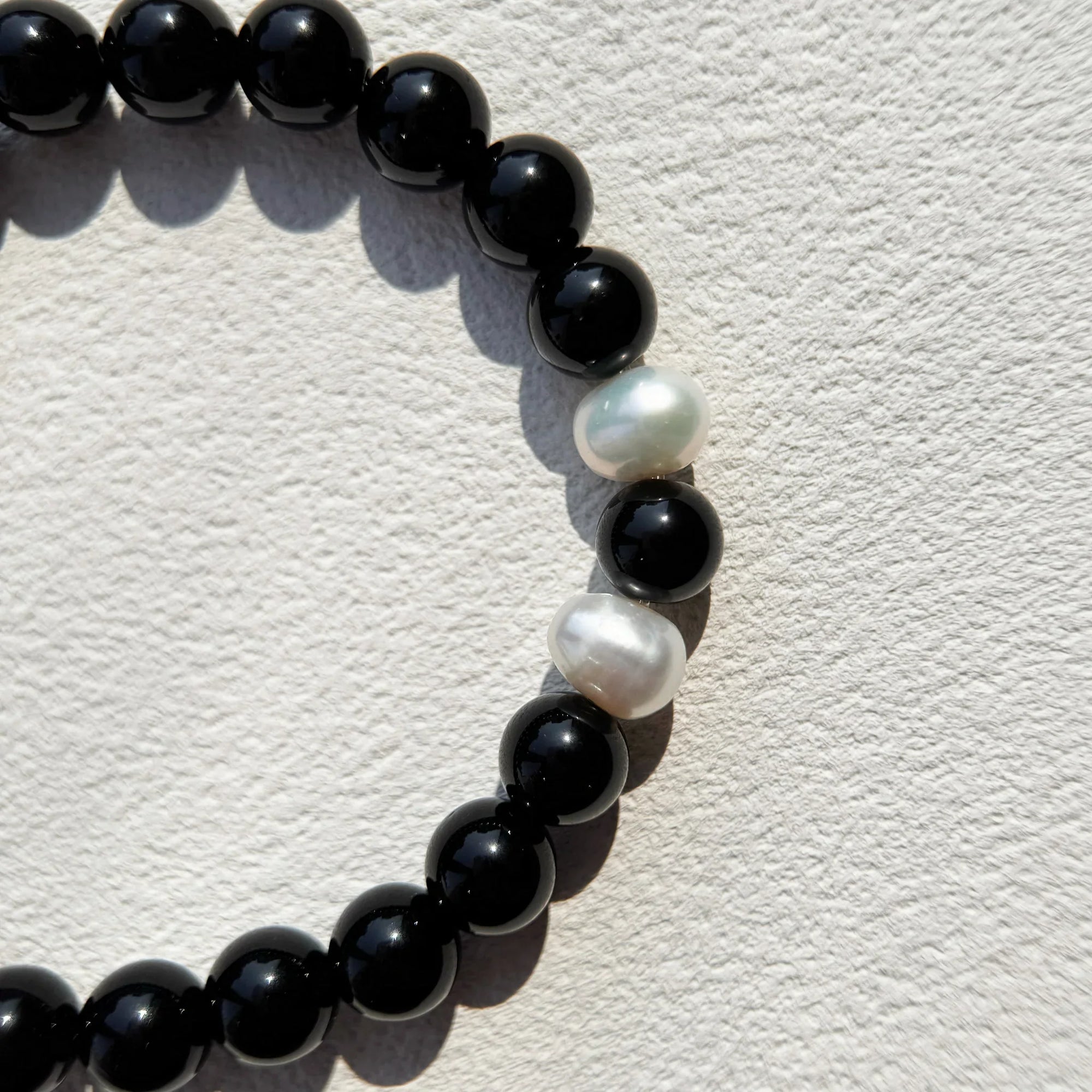 Detail shot of natural Obsidian and pearl combination.
