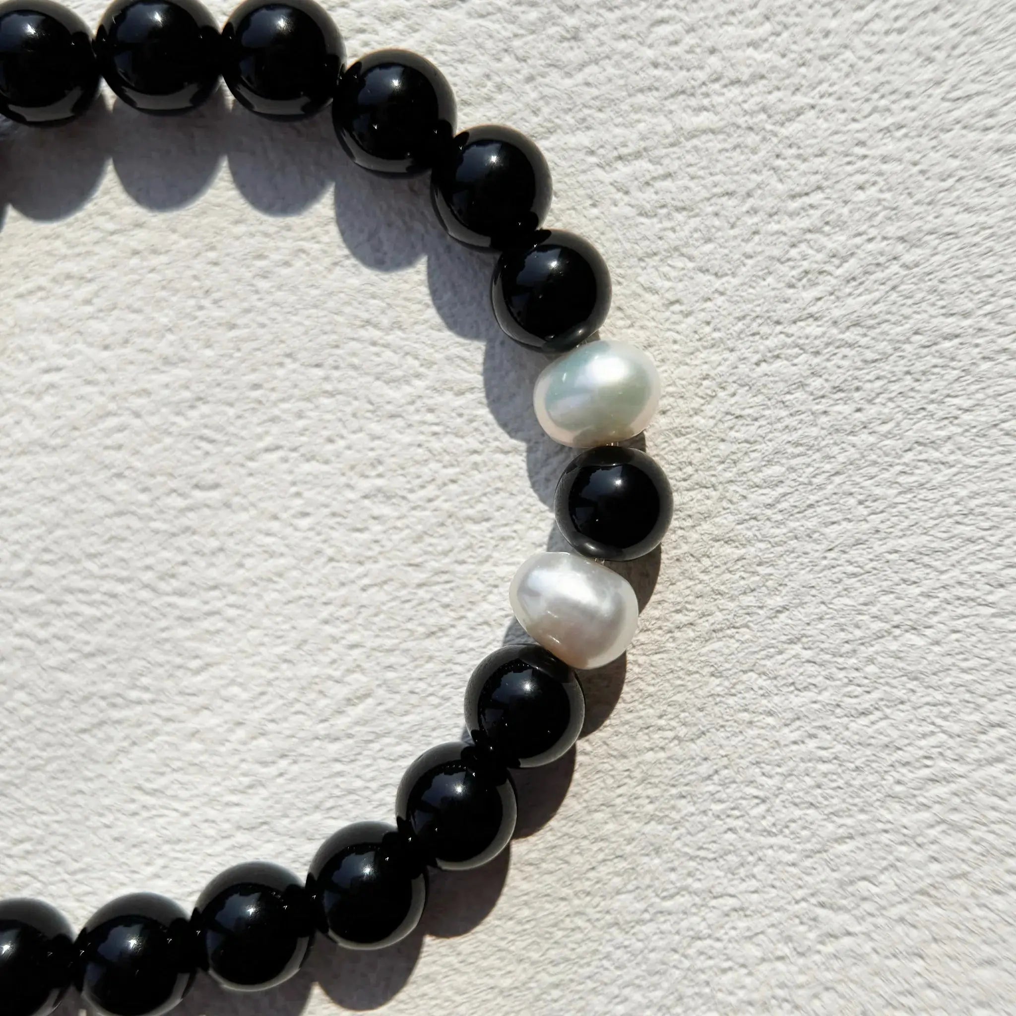 Detail shot of natural Obsidian and pearl combination.