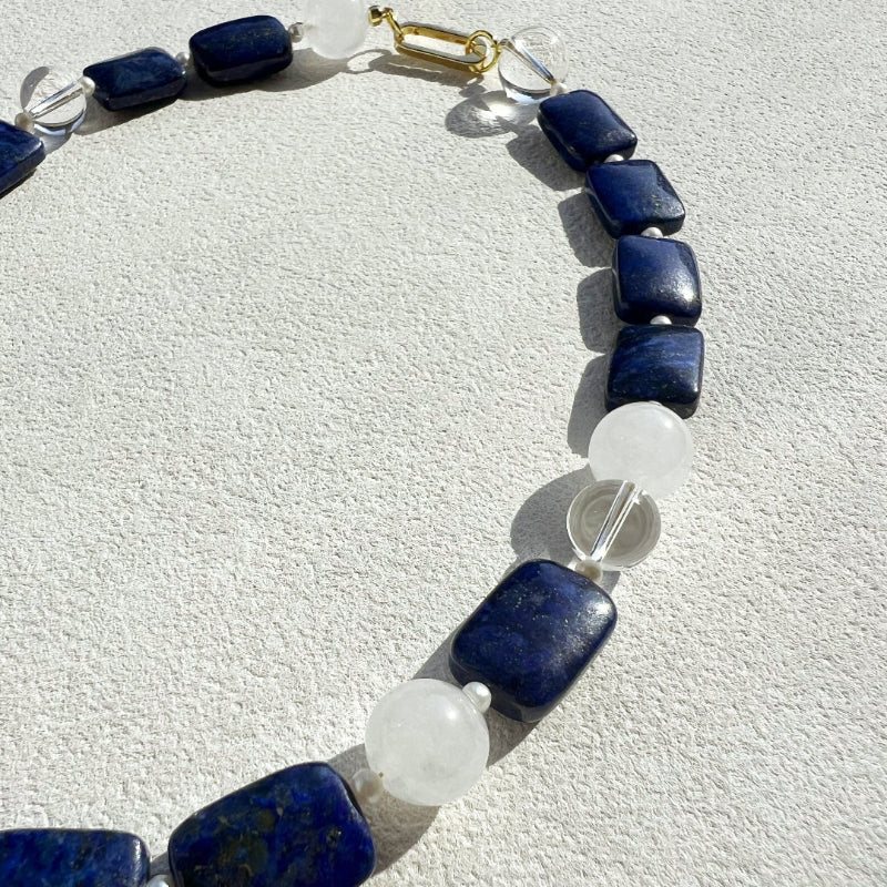 Close-up of Amaré Qinghua necklace showing the misty translucency of white jade, deep blue lapis lazuli, and a lustrous freshwater pearl on an 18k gold-plated chain.
