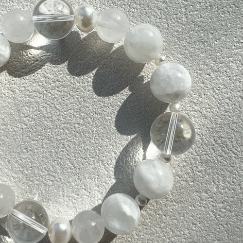 Macro shot contrasting the crystalline clarity of 12mm clear quartz with the soft, organic glow of 3mm accent pearls and misty white jade.