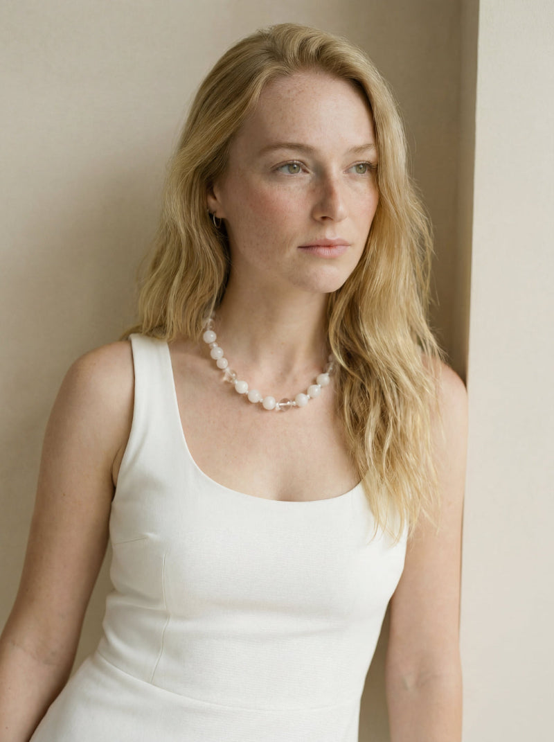 A model wearing the Amaré Qi necklace on the collarbone, showcasing the sophisticated layering of large-scale white phantom quartz and white jade stones.