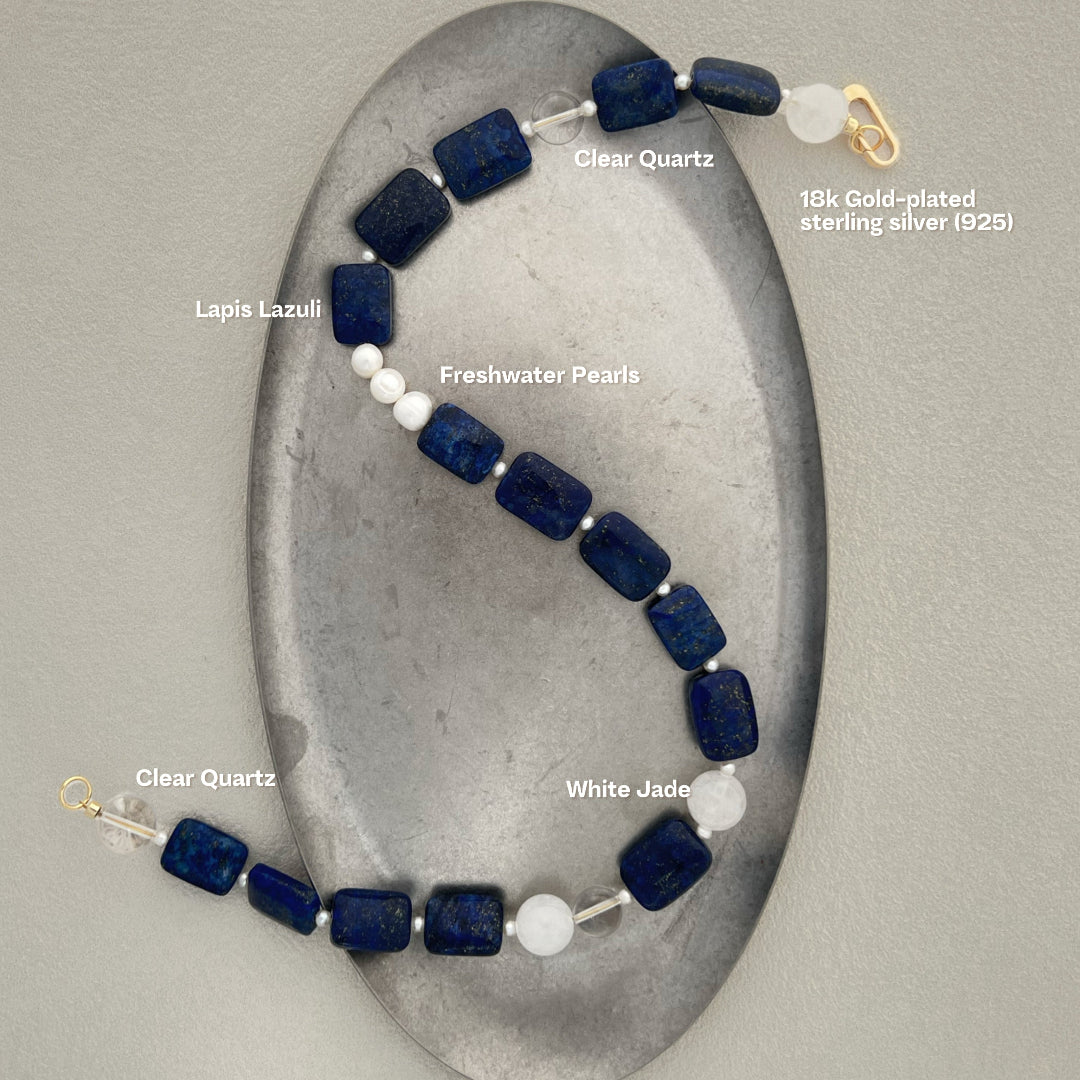 Hand-finished Zen-inspired necklace by Amaré, showcasing the translucent glow of white jade paired with cobalt blue lapis lazuli on a crisp white studio background.
