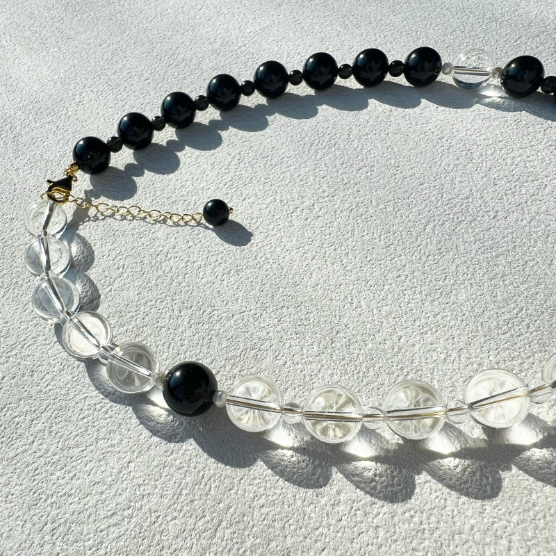 Close-up of the 10mm high-grade clear quartz bead, showcasing its crystal clarity and ability to capture light within the void & form design.