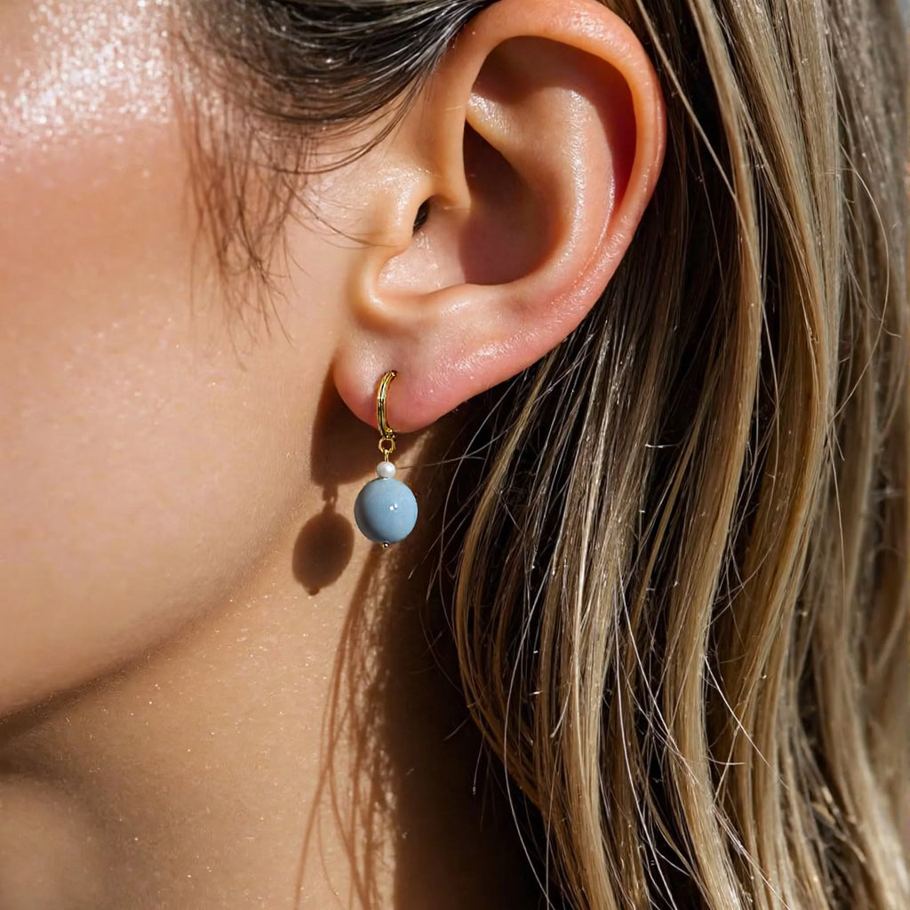Model wearing handmade aquamarine crystal earrings with freshwater pearls – grounding and protective gemstone jewelry