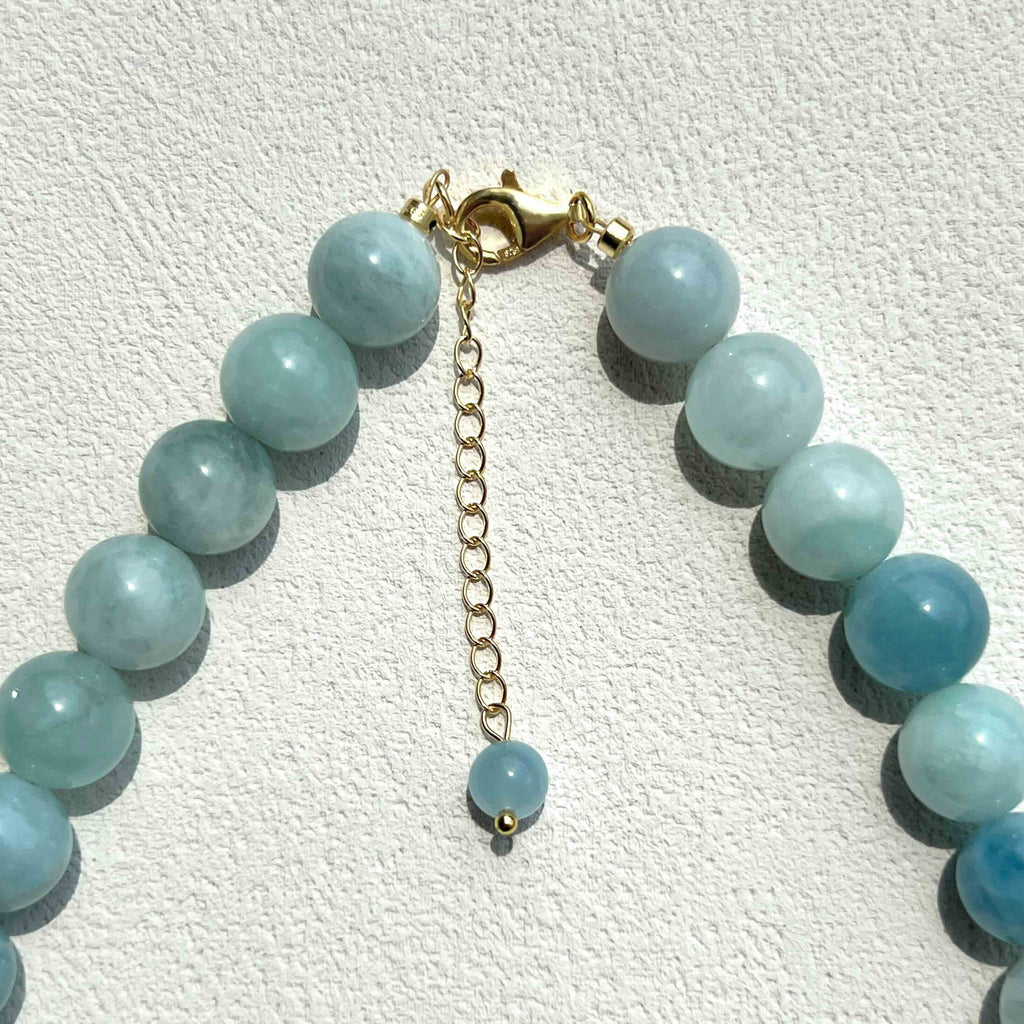 Close-up of handmade Aquamarine crystal necklace with freshwater pearls, showing the natural texture and soft blue color of the stones.