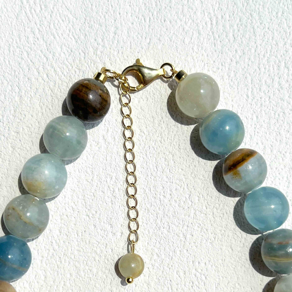 Close-up detail of Blue Calcite Necklace showing soft blue crystal beads, subtle gold accents, and freshwater pearls, highlighting the handcrafted quality and serene elegance.