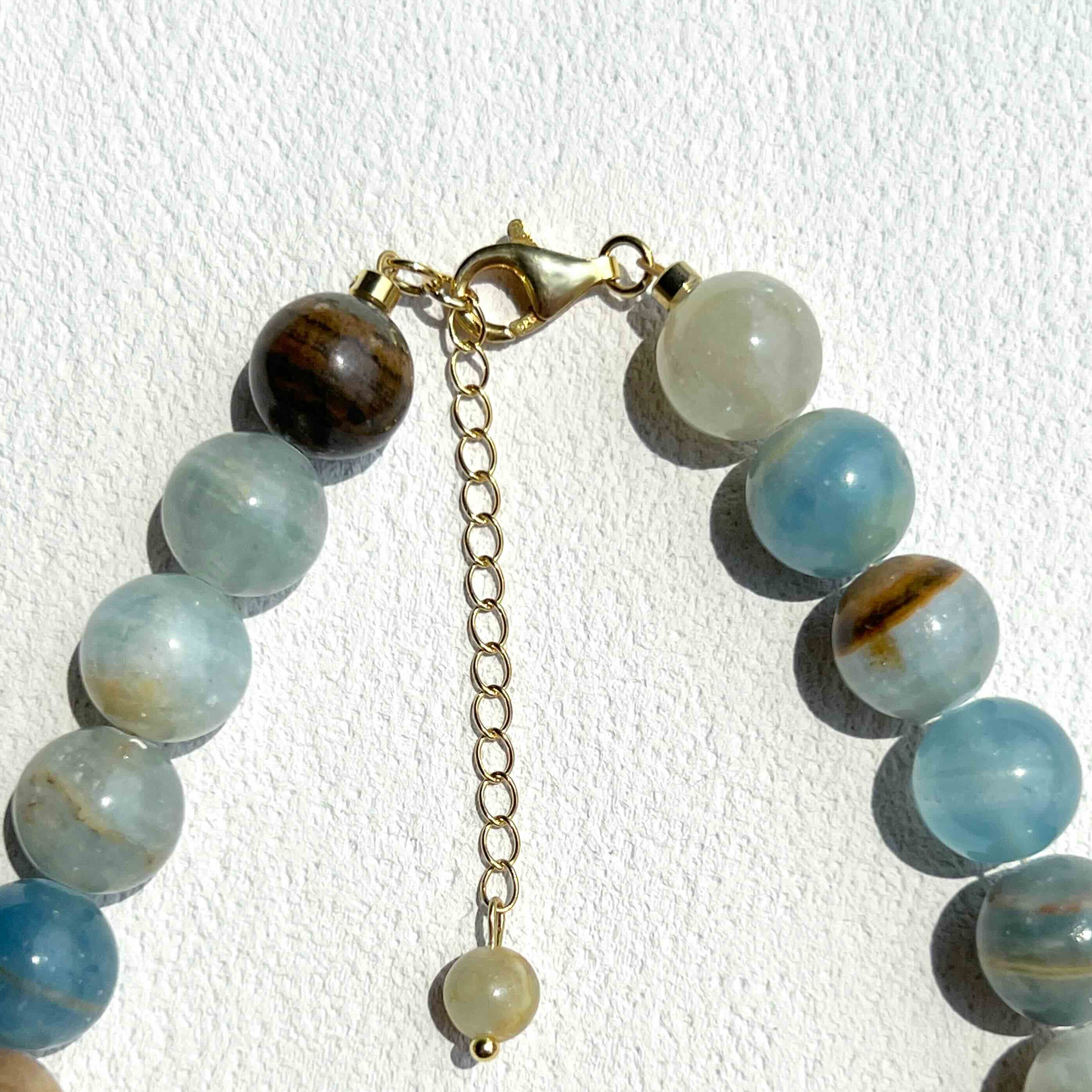 Close-up detail of Blue Calcite Necklace showing soft blue crystal beads, subtle gold accents, and freshwater pearls, highlighting the handcrafted quality and serene elegance.