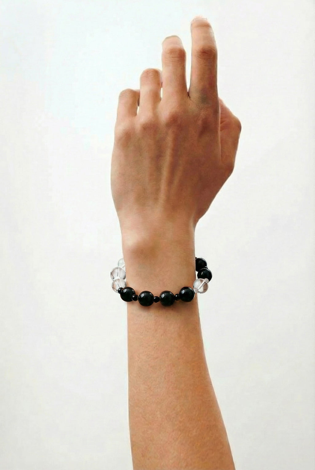 A model wearing the Amaré Yinyang necklace on the collarbone, showcasing the balance of shadow and light within the minimalist void and form jewelry collection.