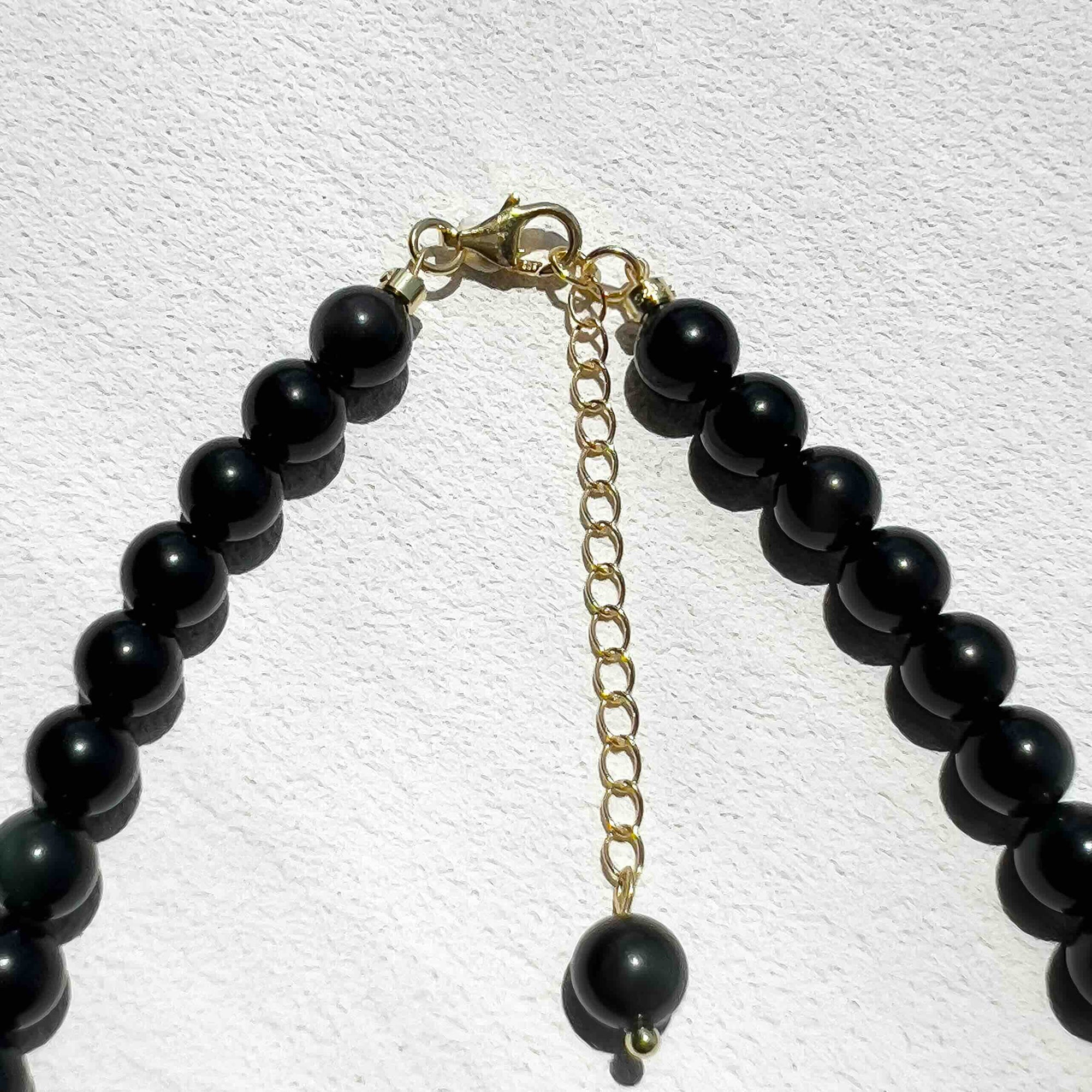 Close-up of the Obsidian Freya Necklace with smooth 6mm black obsidian beads, gold accents, and freshwater pearls, showcasing its grounding energy and elegant handmade design.