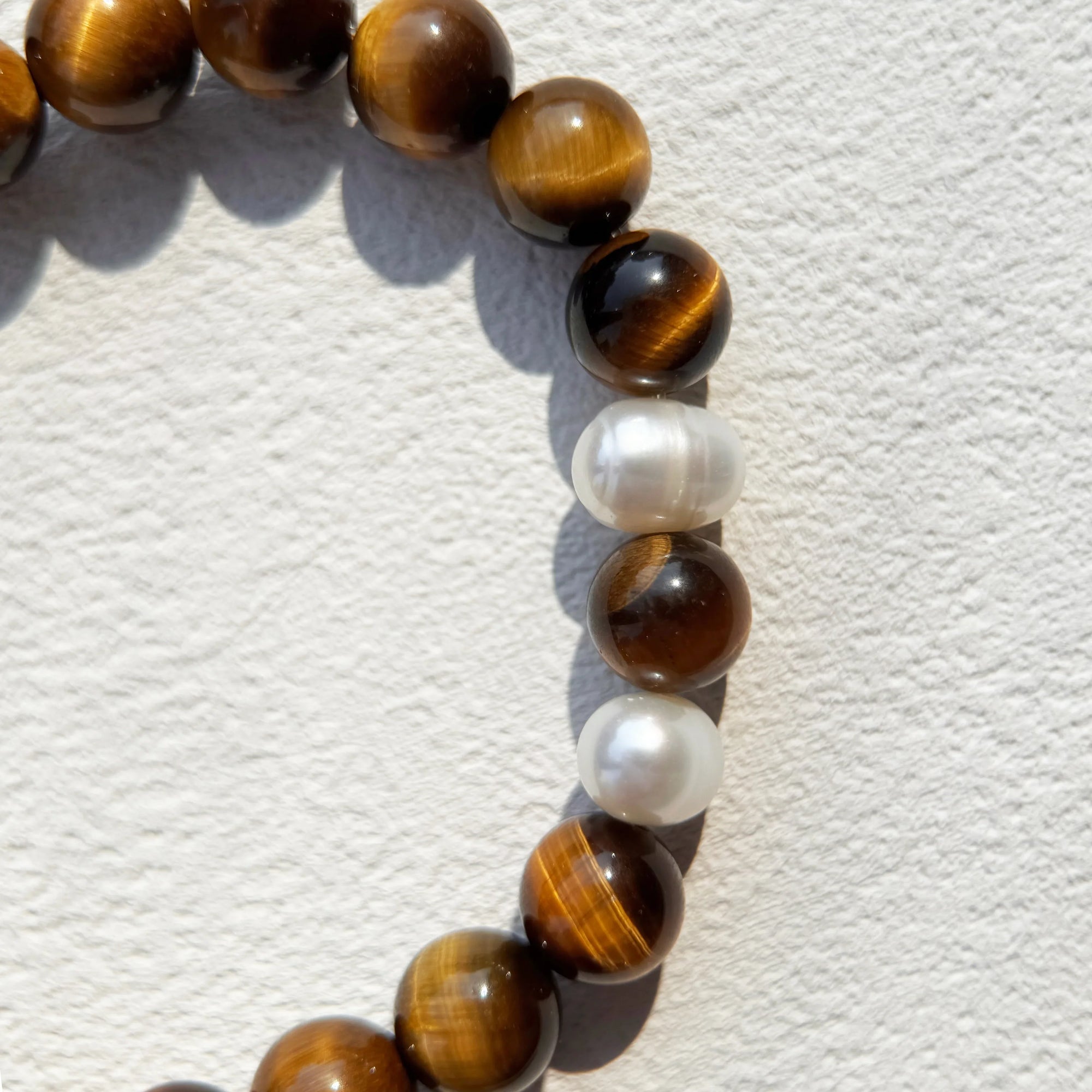 Close-up of Tiger’s Eye beads and pearls for confidence and protection