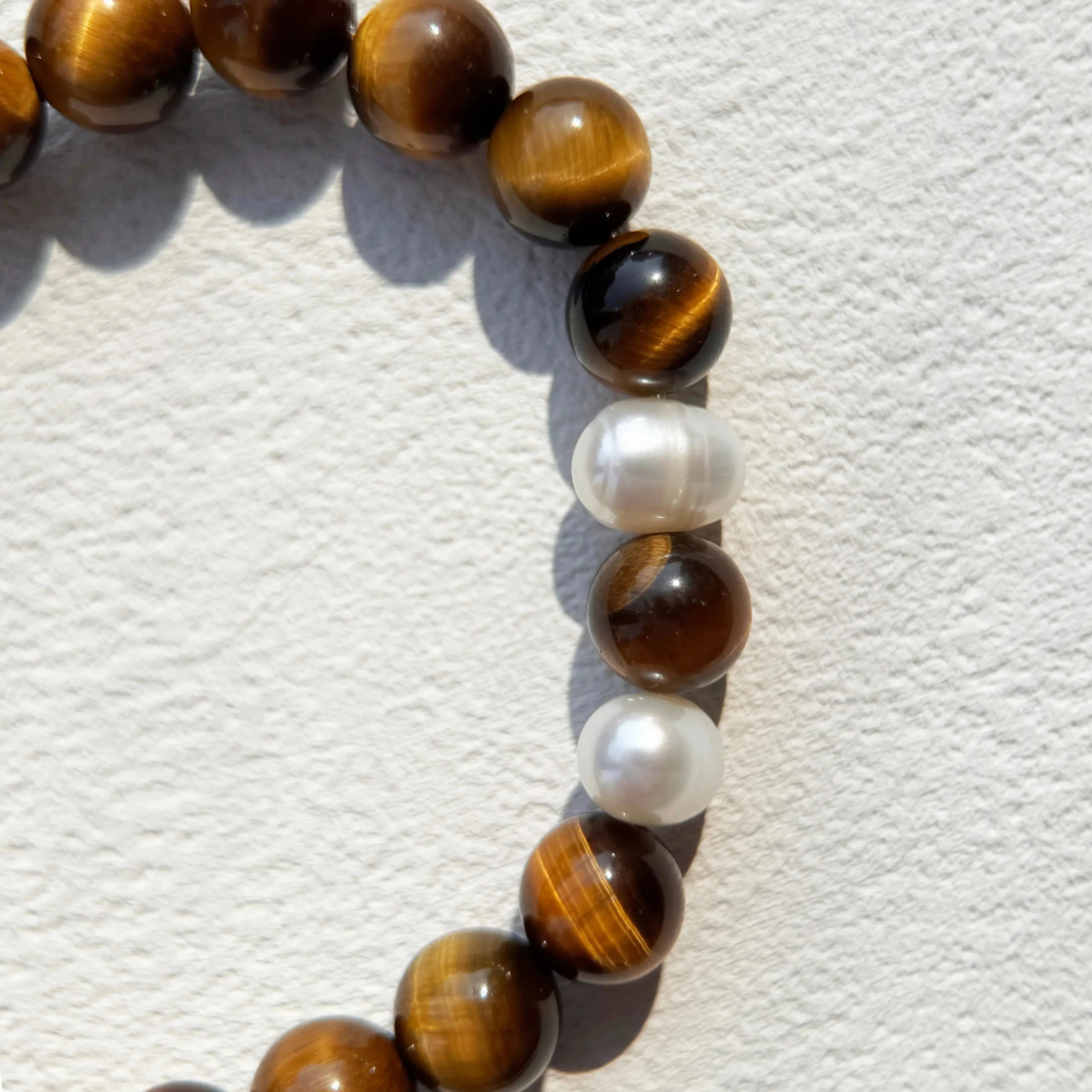 Close-up of Tiger’s Eye beads and pearls for confidence and protection