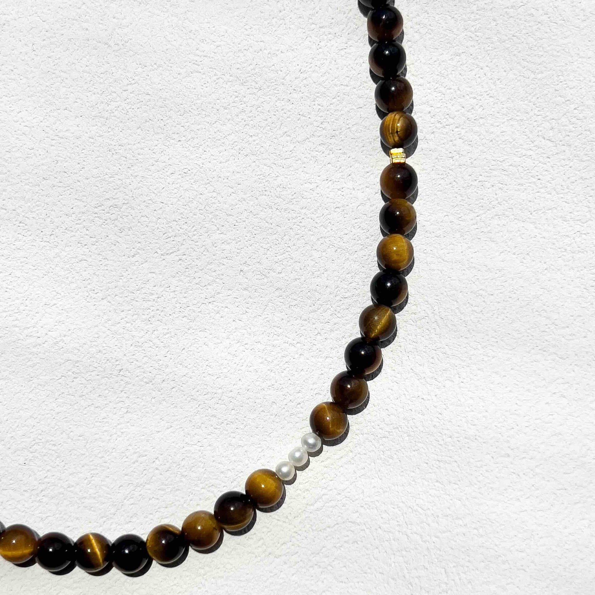 Close-up of the Tiger’s Eye Freya Necklace showing polished 6mm golden-brown crystal beads with subtle gold accents and freshwater pearls, highlighting its natural texture and warm tones.