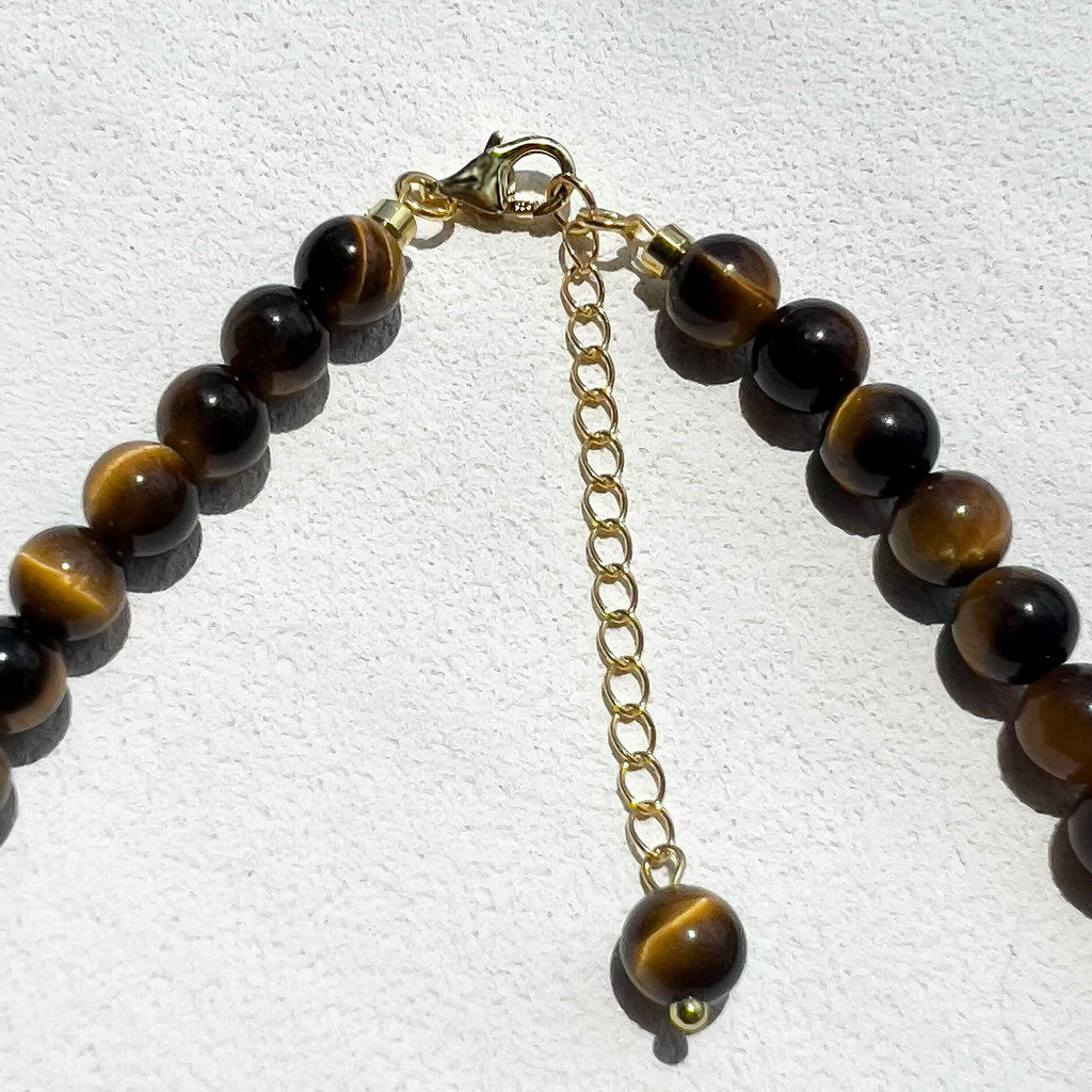 Close-up of the Tiger’s Eye Freya Necklace showing polished 6mm golden-brown crystal beads with subtle gold accents and freshwater pearls, highlighting its natural texture and warm tones.