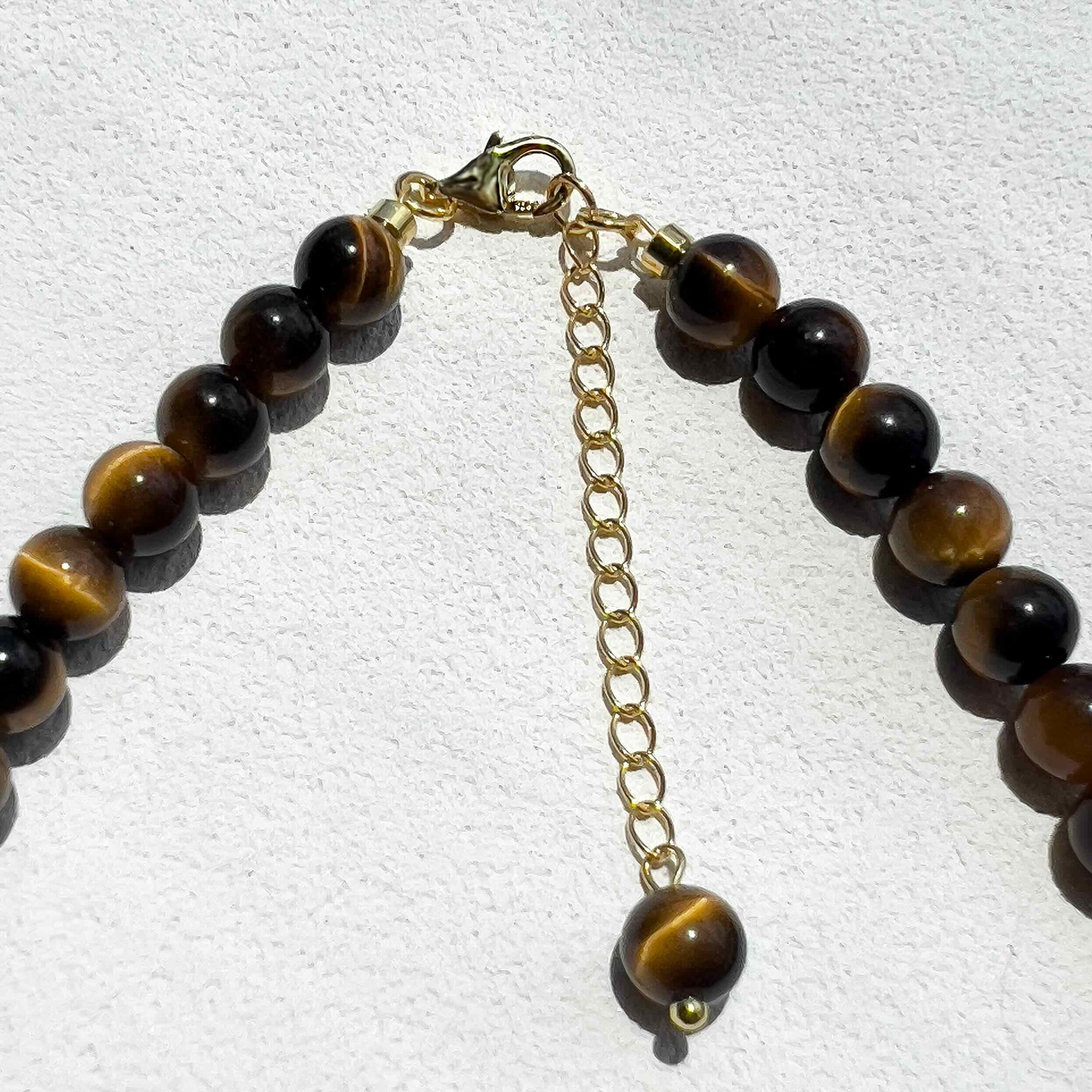 Close-up of the Tiger’s Eye Freya Necklace showing polished 6mm golden-brown crystal beads with subtle gold accents and freshwater pearls, highlighting its natural texture and warm tones.