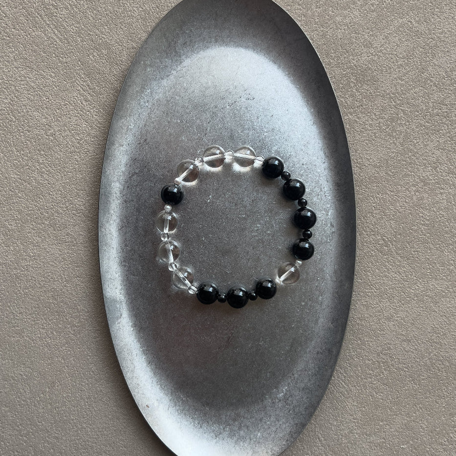 Amaré Yinyang necklace featuring a 10mm black obsidian stone and a 12mm high-grade clear quartz bead with freshwater pearl accents on an 18k gold-plated chain, void and form collection.